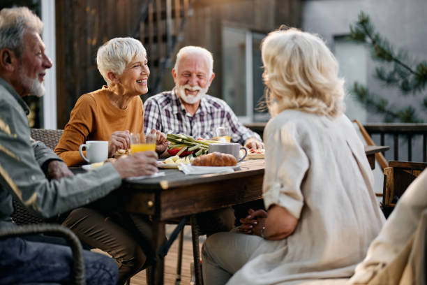 istock Happy senior couples talking during a meal on a terrace. 1409436494