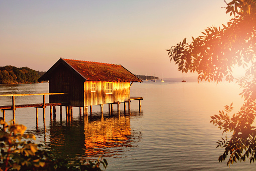 Traditional boathouse at lake Ammersee at sunset