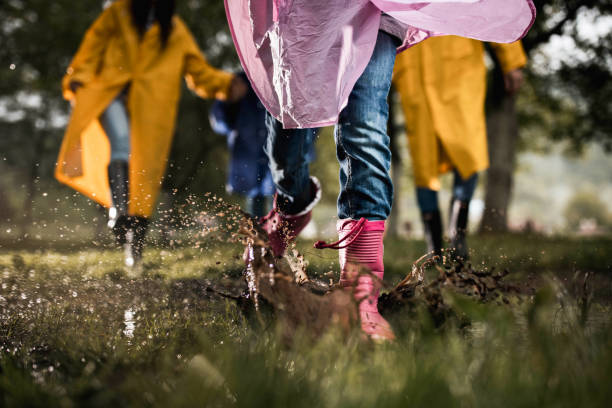 istock Unrecognizable child running through muddy puddle in nature. 1409439186