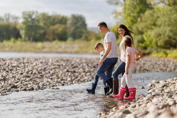 istock Happy family talking while walking through water on the riverbank. 1409439411