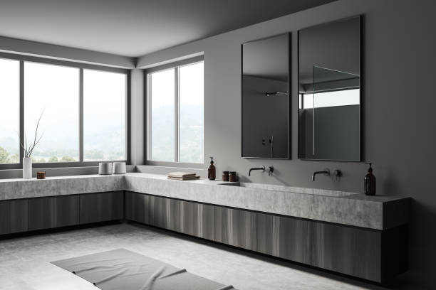 istock Stylish grey bathroom interior with sink, dresser and panoramic window 1409439703