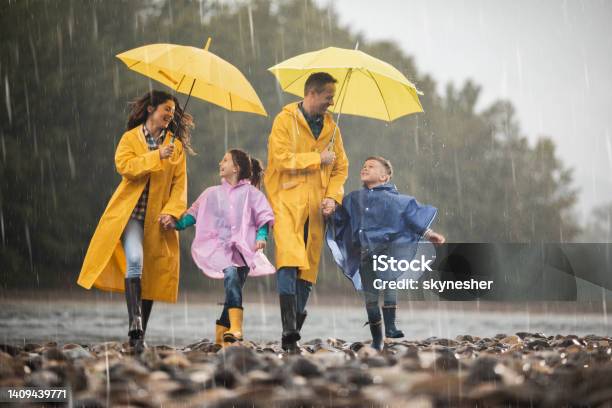Carefree Family In Raincoats Having Fun On A Rainy Day Stock Photo - Download Image Now