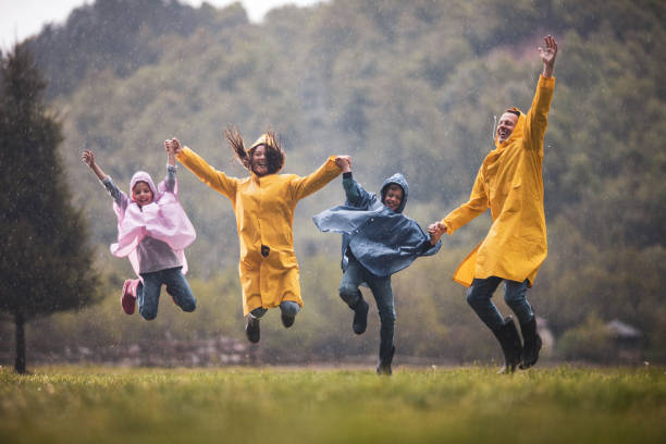 istock Carefree family having fun while jumping on rain in nature. 1409440343