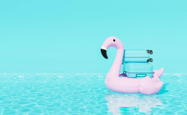 3D suitcases on inflatable toy floating in pool stock photo