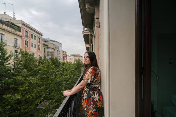 istock Woman looking out on a balcony 1409440987