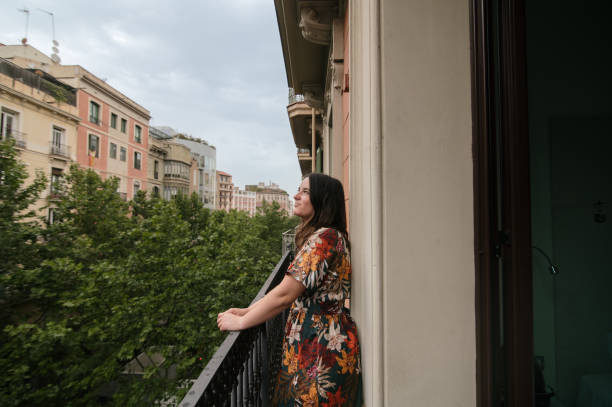 istock Woman looking out on a balcony 1409440993