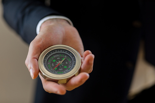 Businessman holding a navigation compass