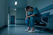医療看護師は、失敗と患者の体調コンセプトの後に欲求不満と悲しみで病院の廊下に座っています