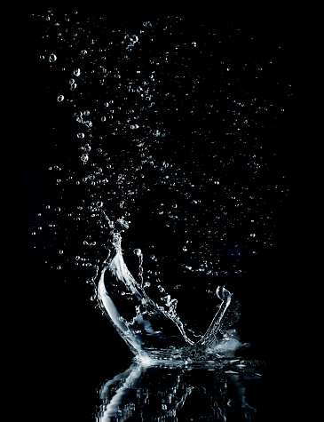 Water splash isolated on black background. Water crown splash. On black background. Side view.