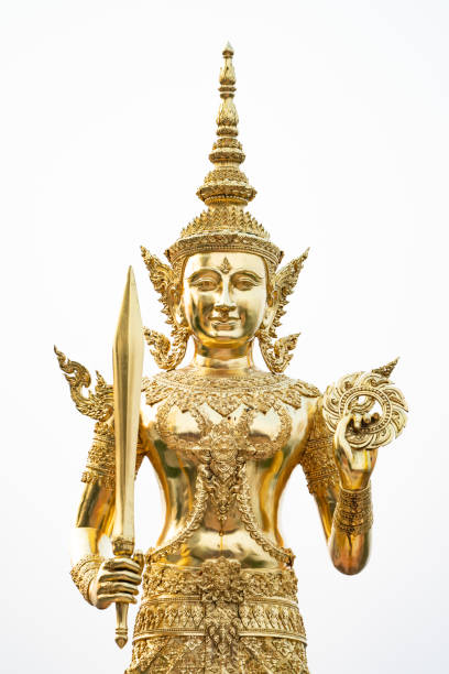 istock A golden graven image standing with a sword and rowel in his hand. Jada's multiple layers are placed on his head. He was standing on golden bases against a white backdrop 1409444157