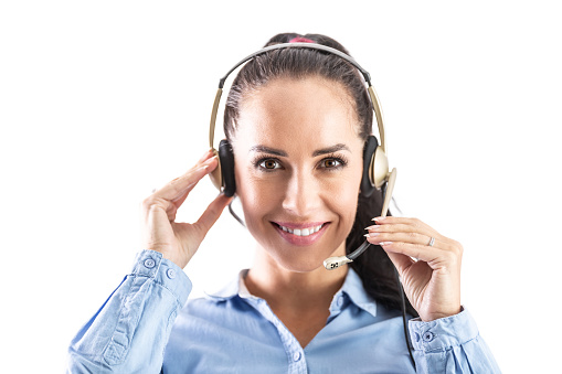 Beautiful smiling call centre worker with headset with microphone smiling into the camera.