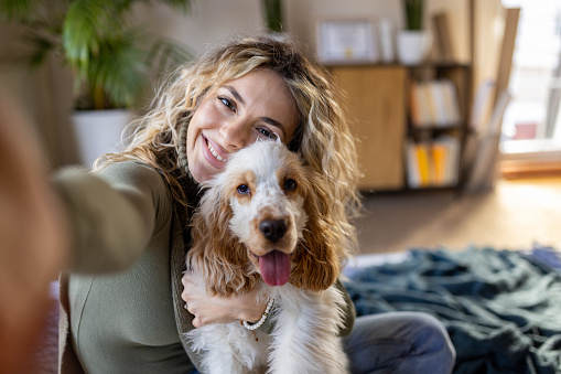 Portrait of young Caucasian woman taking selfie with her Cocker Spaniel dog