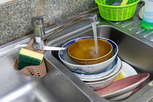 Dirty dishes in the asian house kitchen sink in evening