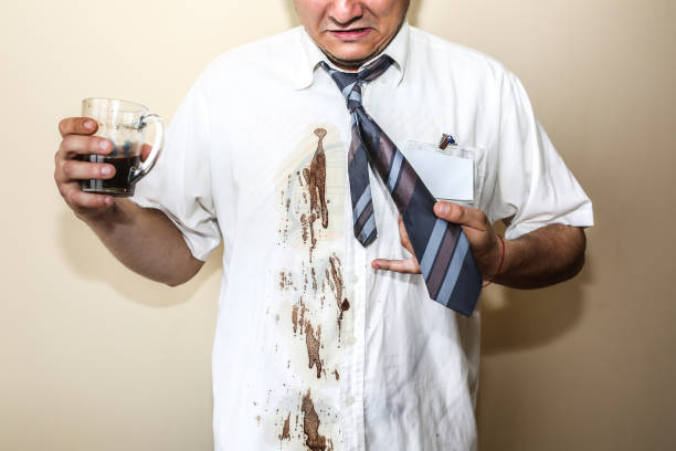 Office worker spills coffee on white shirt. Occupational burnout. Unhappy manager with mug in hands. Stressful job. Desperate man.