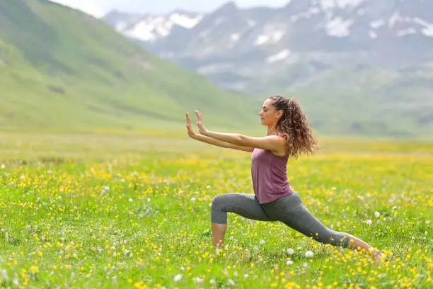 Photo of Woman practicing tai chi in a high mountain field