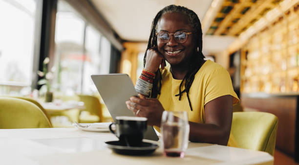 istock Happy mature woman working with a digital tablet in a cafe 1409450657