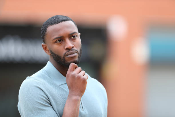 istock Black man thinking looking at side in the street 1409450800