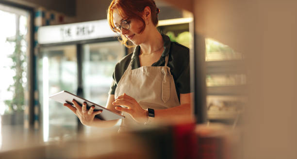 식료품 점에서 디지털 태블릿을 사용하는 쾌활한 상점 주인 - 소기업 뉴스 사진 이미지