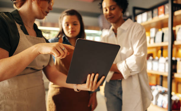 istock Grocery store manager using a digital tablet with her employees 1409451080