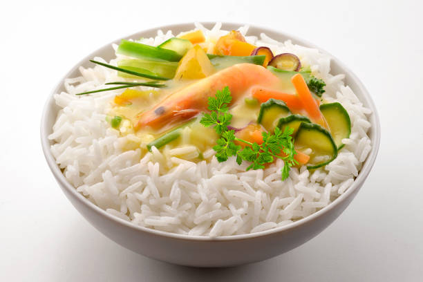 White bowl with shrimp vegetables basmati rice and curry sauce isolated on white background