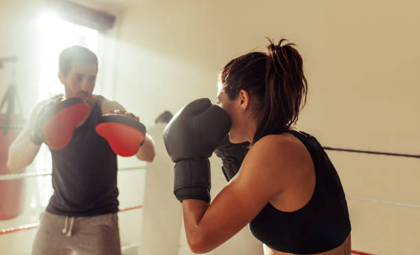 istock Female boxer training with a coach in a gym 1409452174
