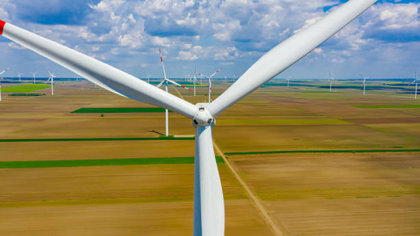 istock Above close view on large wind power turbine as standing among agricultural fields, generating clean renewable electrical energy 1409453399