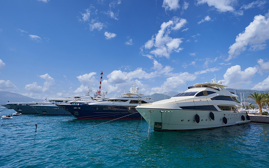 Moored luxury yachts against blue sky in Montenegro.