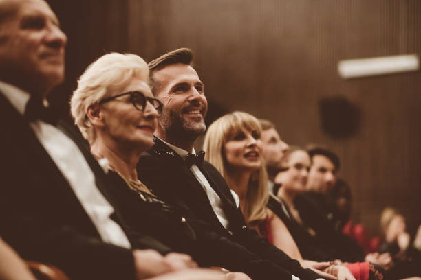 istock Smiling spectators sitting in the theater 1409454898