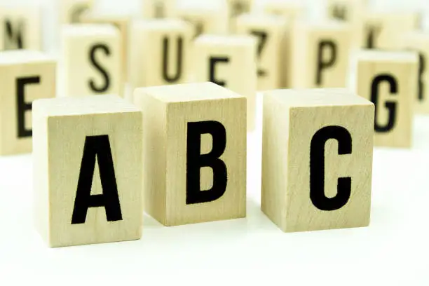 A B C letters on wooden cubes against white background