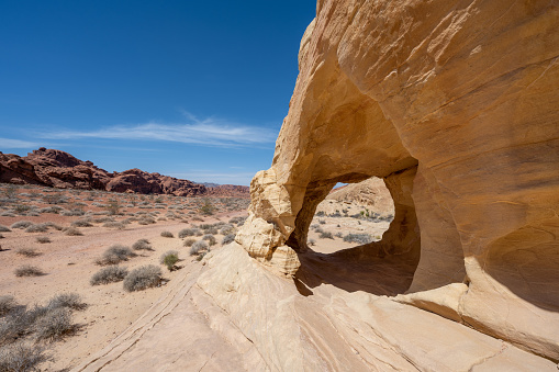 A natural arch seen in Valley of Fire during a hot day in the hot desert landscape in Nevada, USA.