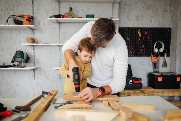 istock Little boy drilling with his father in carpentry workshop 1409458160
