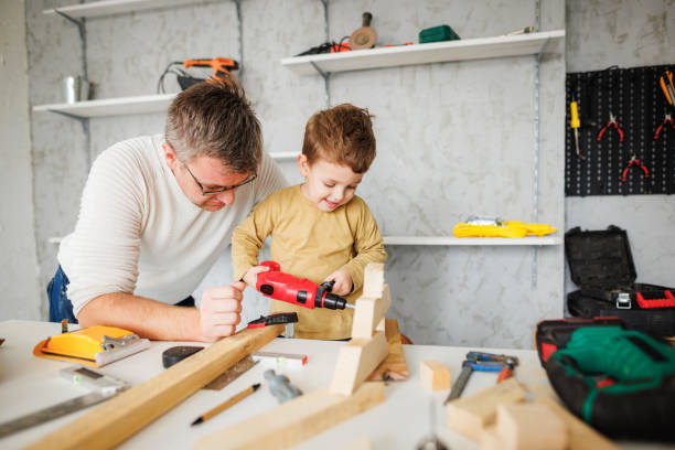istock Smiling little boy have fun with his father in workshop 1409458261