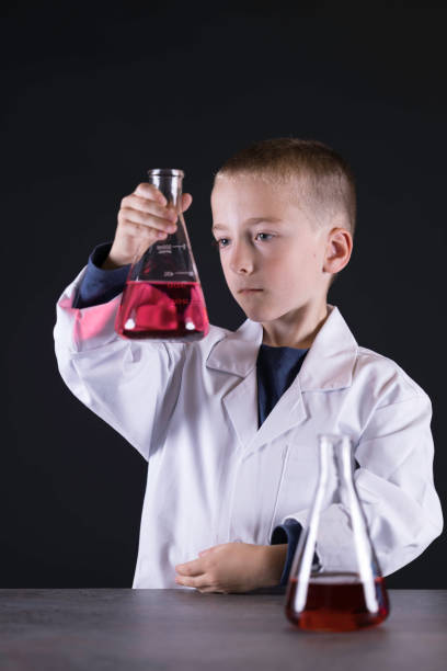 Seven year old wearing a white lab coat ready to experiment with chemicals.