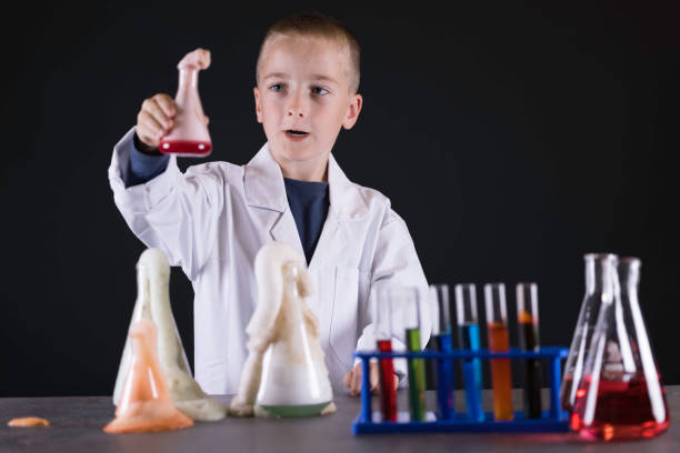 Seven year old wearing a white lab coat conducting a chemistry experiment.