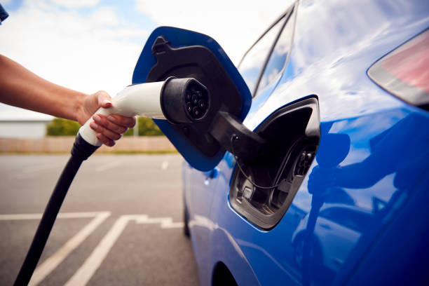 istock Close Up Of Hand Attaching Charging Cable To Environmentally Friendly Zero Emission Electric Car 1409460957
