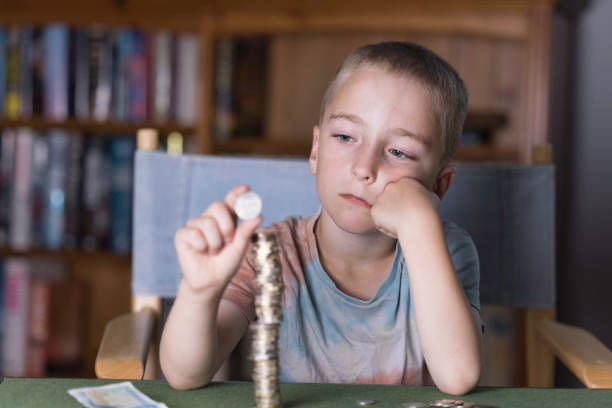 Seven year old counting his pocket money. Focus on boy's face.