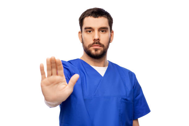 istock doctor or male nurse showing stop gesture 1409462702