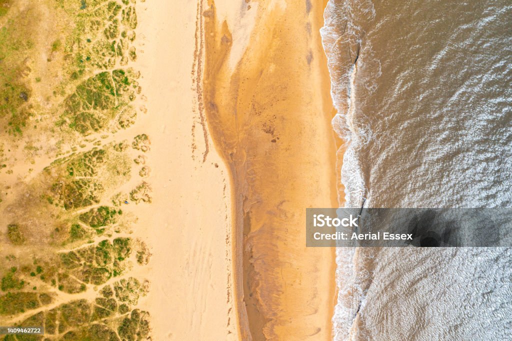 Aerial photo of Southwold's beach, Suffolk. A drones top down view of the beach at Southwold. Showing even sections of sea, sand and sand dunes. Sand Dune Stock Photo