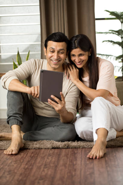istock Cheerful couple using digital tablet at home 1409463472