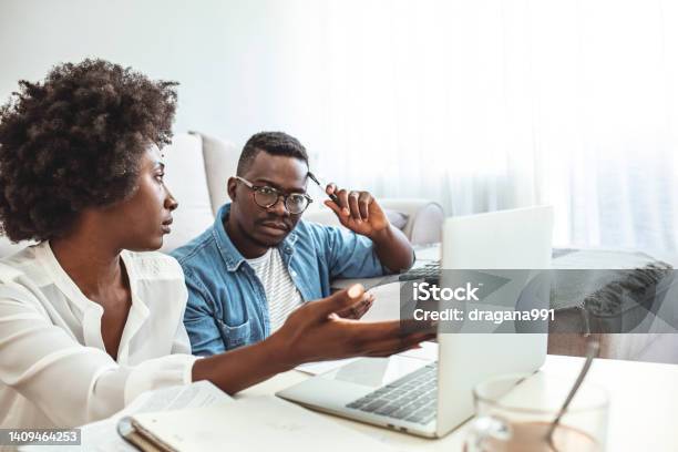 Young Couple Calculating Their Domestic Bills At Home Stock Photo - Download Image Now