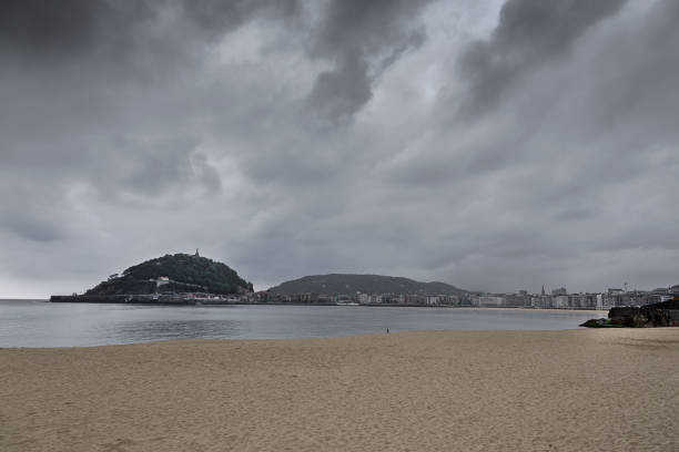 dense storm clouds advancing over the sea in daylight, capturing the tension and power of approaching coastal weather along a rugged shoreline