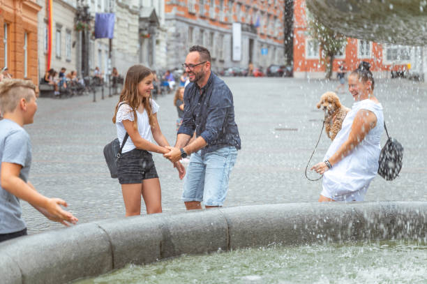 familia divirtiéndose en la ciudad - sprinkling can fotografías e imágenes de stock