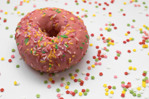 pink donut with sprinkles on a white background