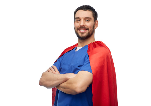 healthcare, profession and medicine concept - happy smiling doctor or male nurse in blue uniform and red superhero cape over white background