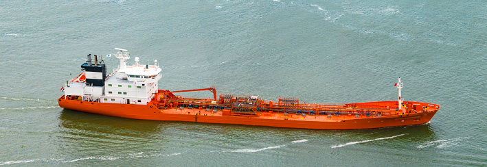 Tanker ship for transporting chemical or oil products sailing on calm water seen from above
