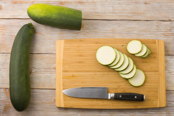 istock Slice the zucchini on a cutting board with a knife. Flat lay 1409472452
