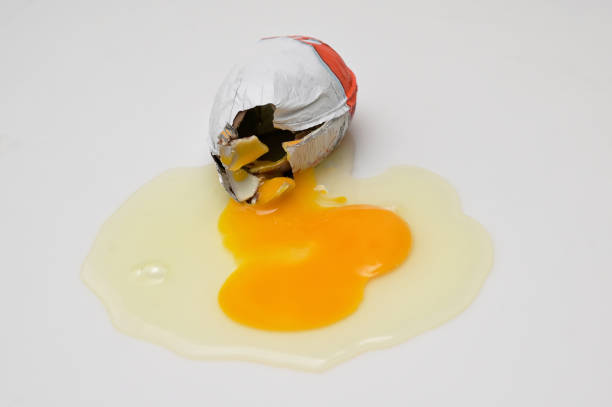 треснувшее яйцо с желтком из шоколадного яйца-сюрприза - kinder surprise стоковые фото и изображения