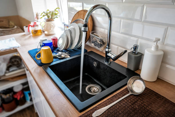 l'acqua che fuoriesce da un rubinetto in acciaio inossidabile della cucina nel lavandino - kitchen sink foto e immagini stock
