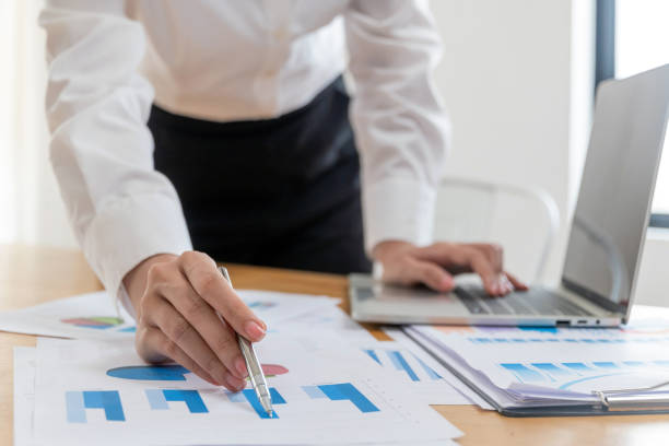 istock business people hand working and calculating about graph chart finance with document report on desk at home office, meeting, digital online marketing and financial business, technology concept 1409475300
