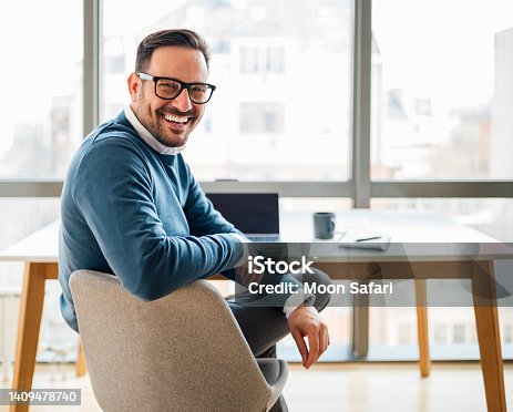 istock Portrait of young smiling happy handsome successful businessman entrepreneur freelancer working looking back. 1409478740